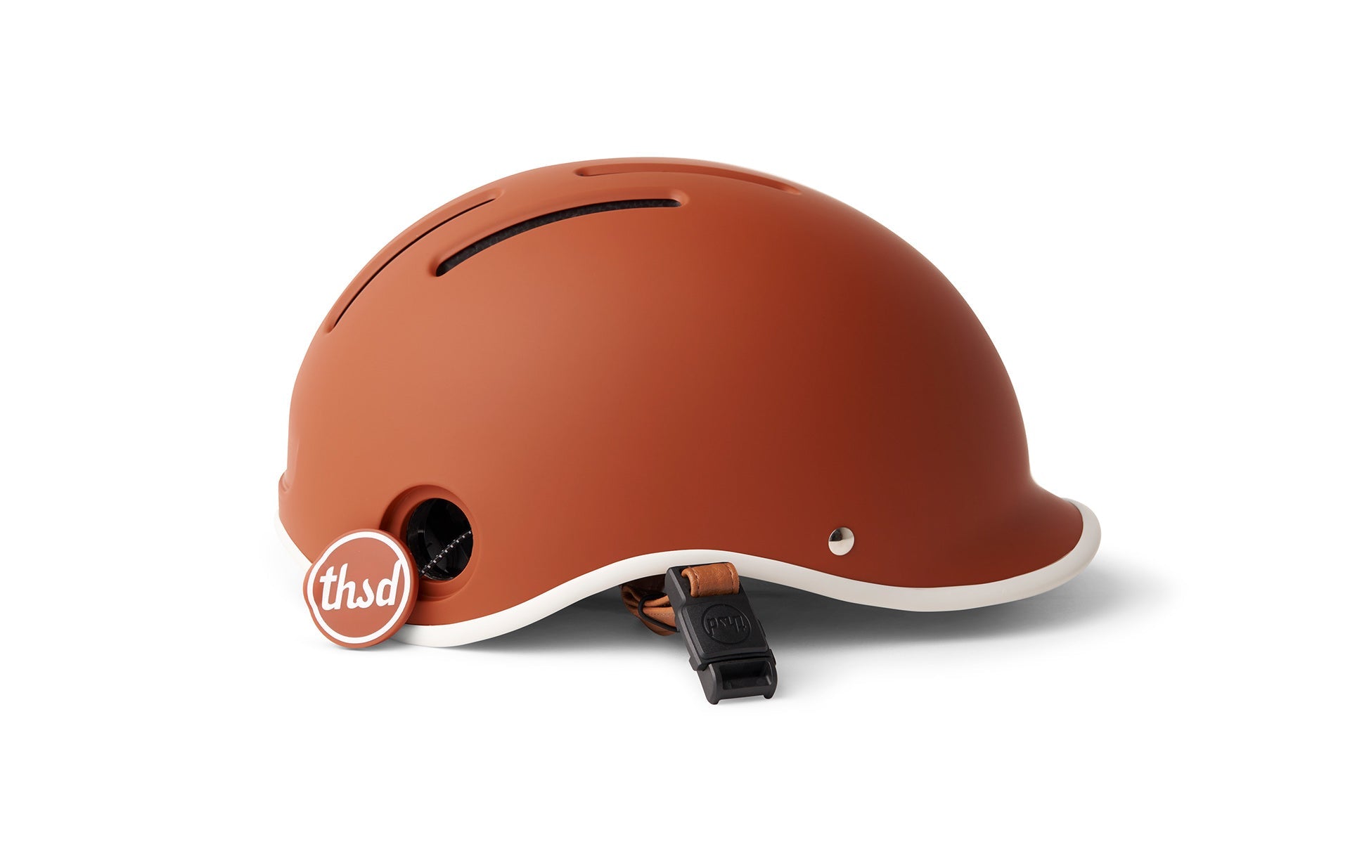 Brown helmet with white exterior edge and white interior shell displayed on a white backdrop with black buckle attachment visible