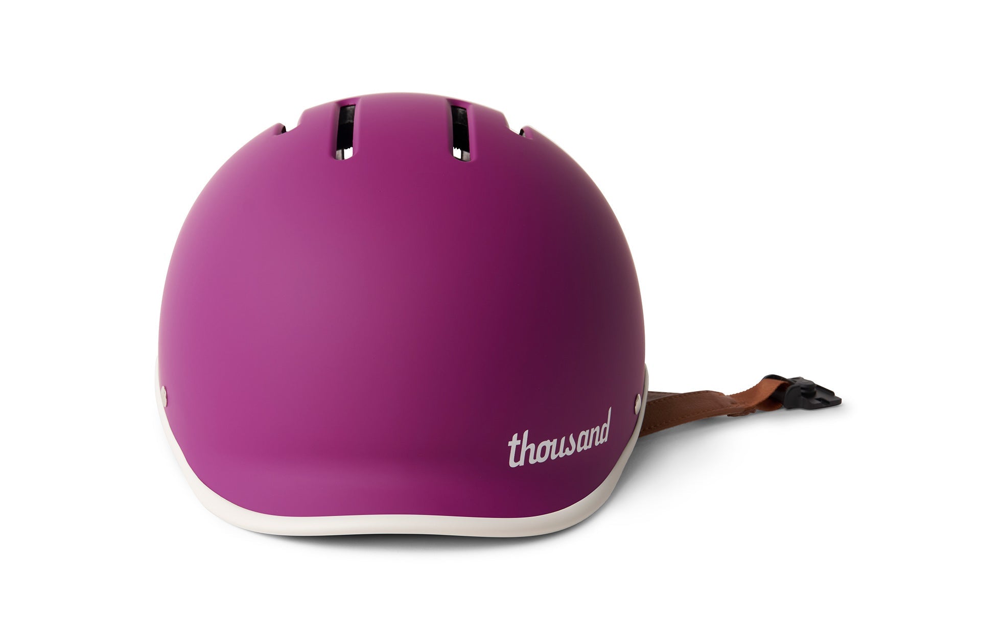 Pink skateboard helmet with buckle strap with white underlayer and the word Thousand branded on the front.