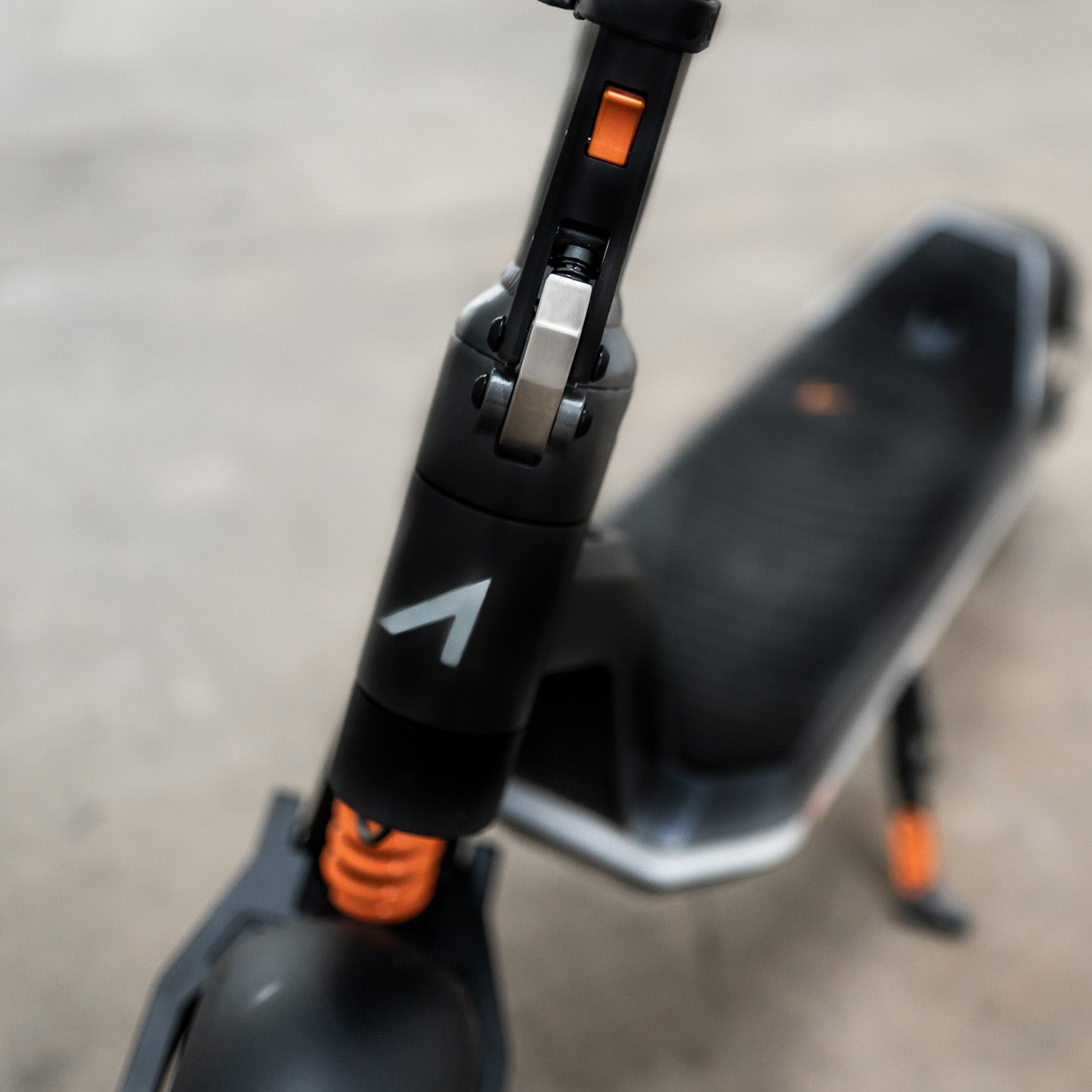 Close-up of a scooter handlebar with visible brand logo on a blurred background