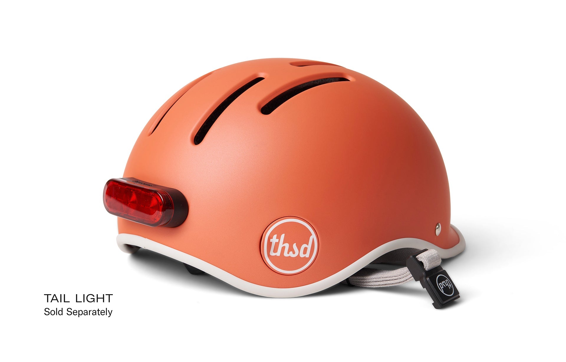 Orange helmet with white trims and 'thsd logo and 'tail light sold separately' text.