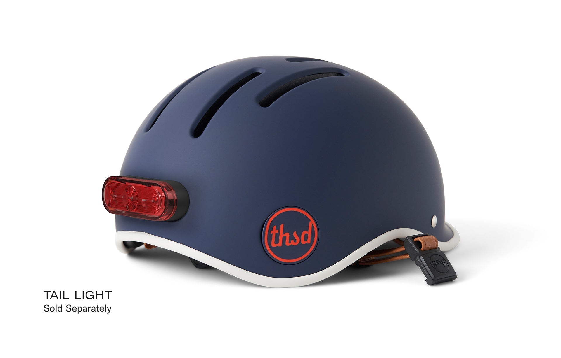 Navy blue helmet with tan strap attached to rear, a red light affixed to the outside, the red logo in front and the text Tail Light underneath the image.