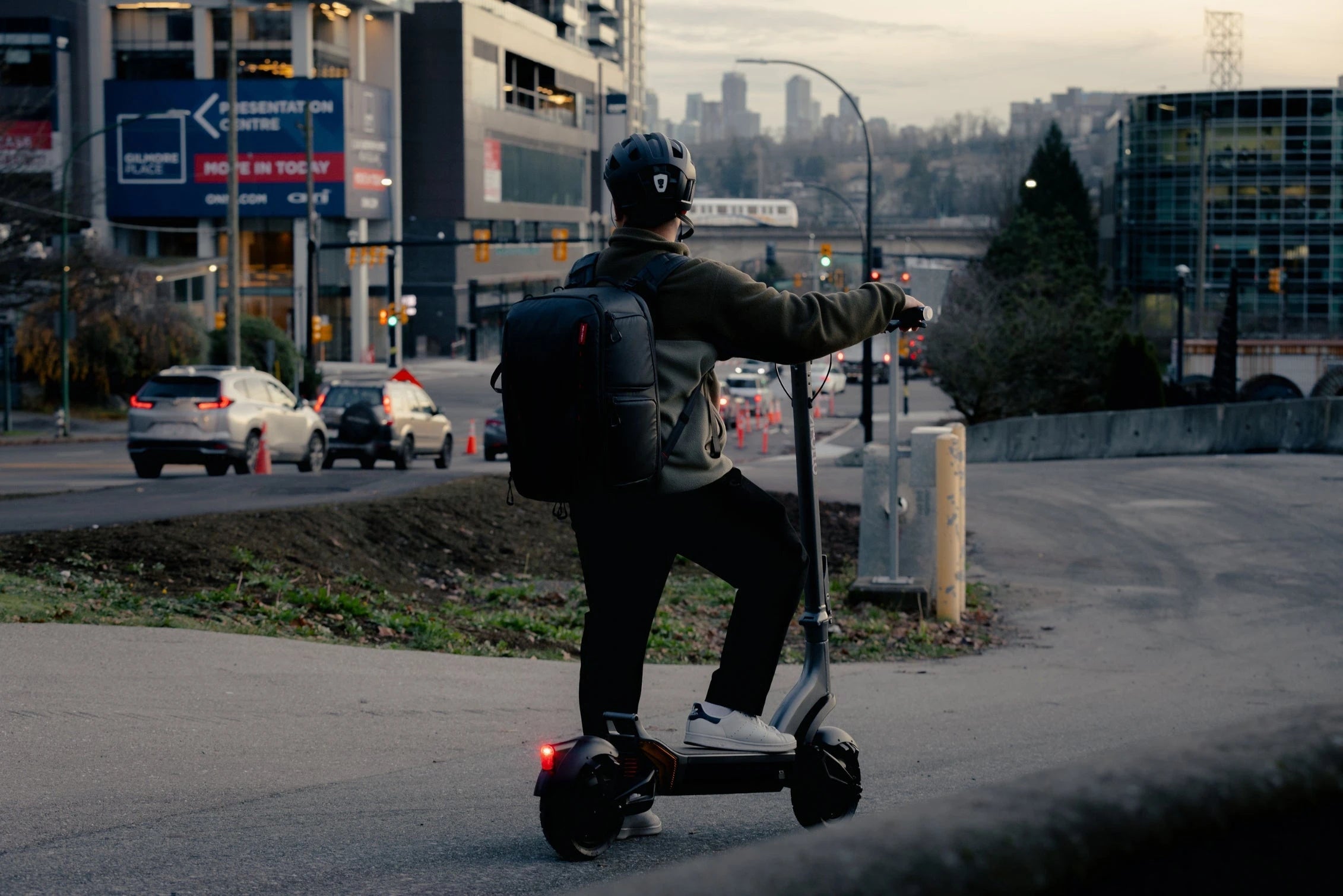 sale collection image - man stopped with one foot on Apollo City electric scooter, looking at the city traffic