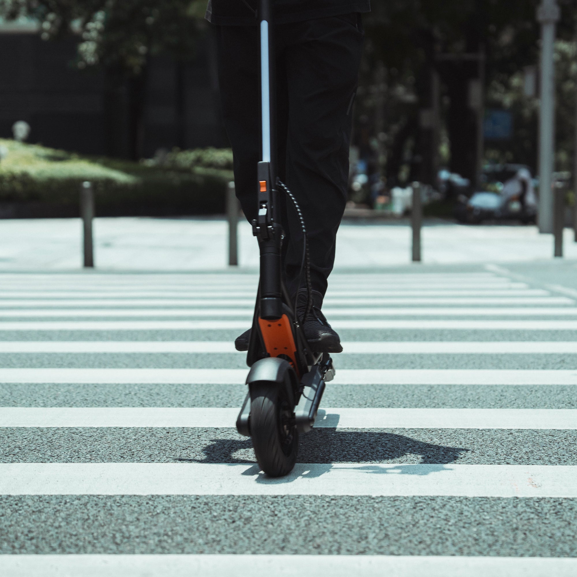 Apollo Explore 2.0 electric scooter riding across a city crosswalk.