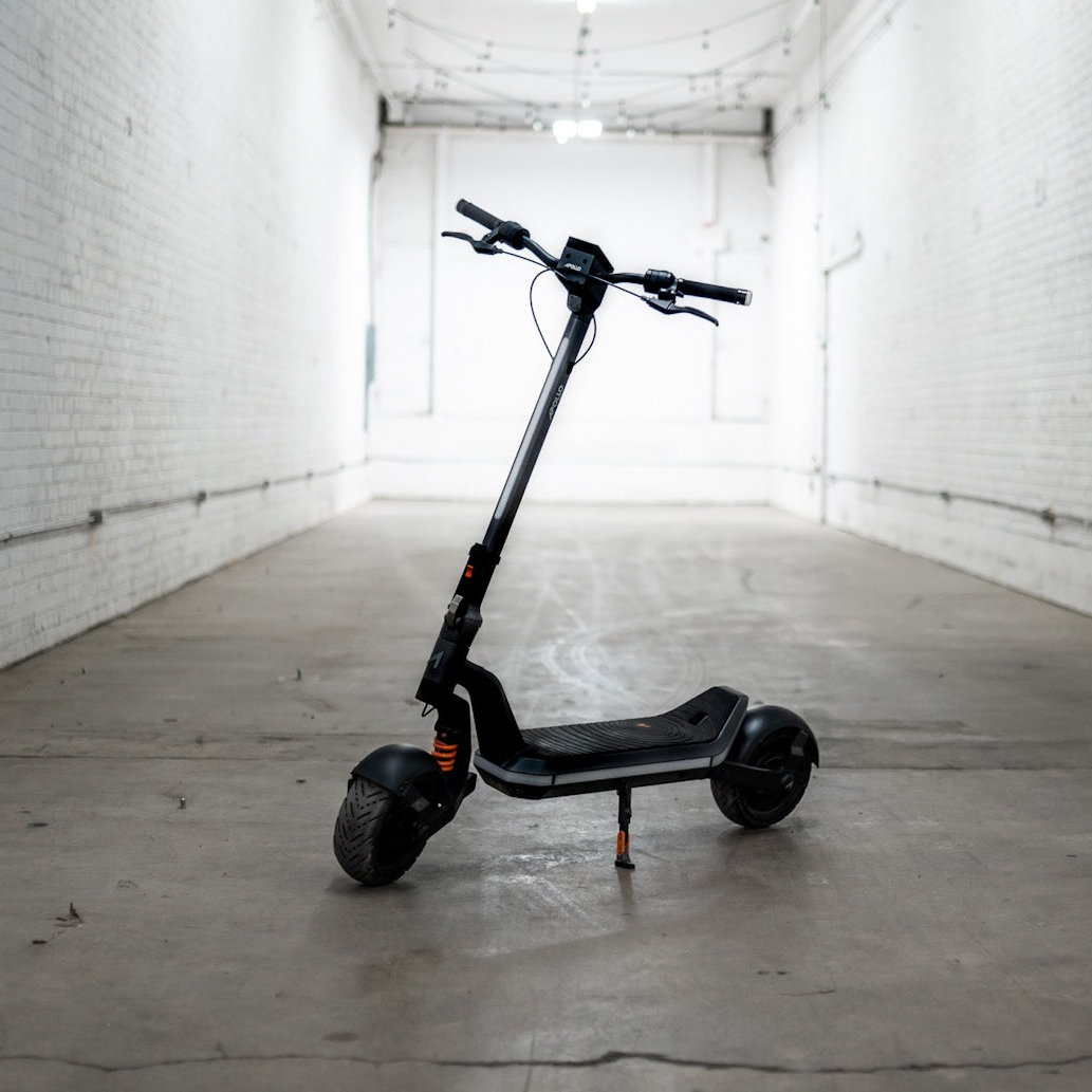 Black electric scooter in a white-walled room